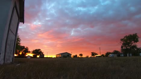 Timelapse---Gruesas-Nubes-Rojas-Y-Azules-Moviéndose-Sobre-La-Cabeza-De-Un-Patio-En-Un-Pequeño-Pueblo-Al-Lado-De-Un-Viejo-Hospital-Abandonado-Cerca-De-Alberta-Canada-Filmado-Durante-El-Atardecer