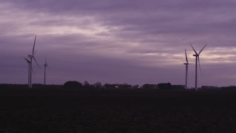 windmills spinning in the pink skies of england