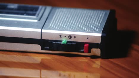 dictaphone lying on a polished table top in a darkened room