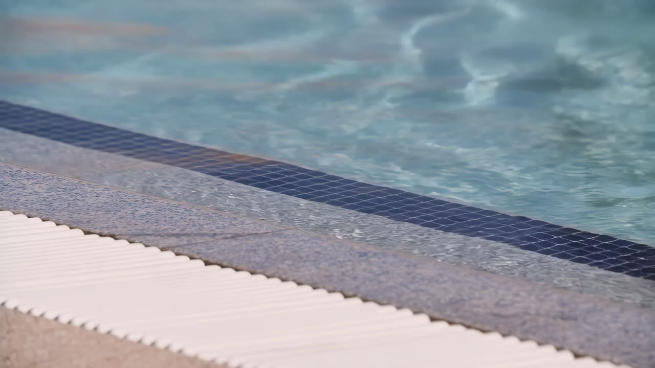 Close-up of swimming pool steps with clear blue water