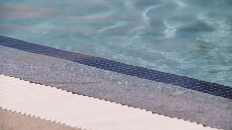 Close-up of swimming pool steps with clear blue water