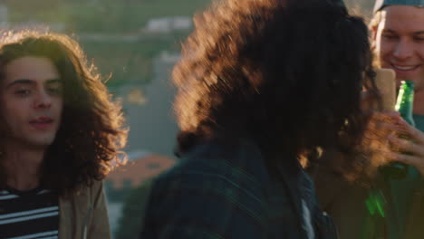group of diverse friends hanging out dancing together mixed race man enjoying rooftop party dance music at sunset drinking alcohol having fun on weekend gathering