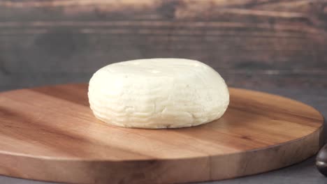 queso blanco redondo en tabla de corte de madera