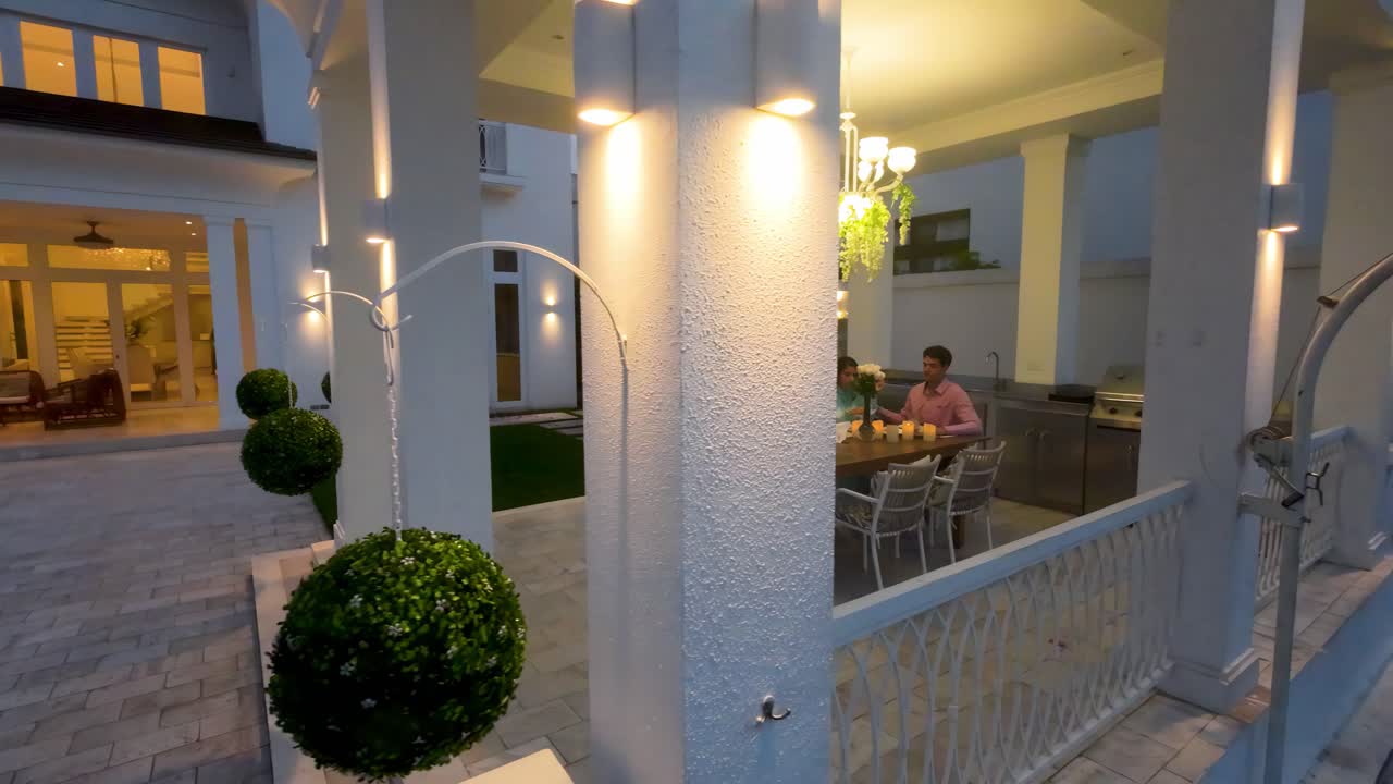 Ett par äter middag vid trädgårdspaviljongen till en lyxig herrgård vid solnedgången i Lagos de Batan, Samborondon, Ecuador.