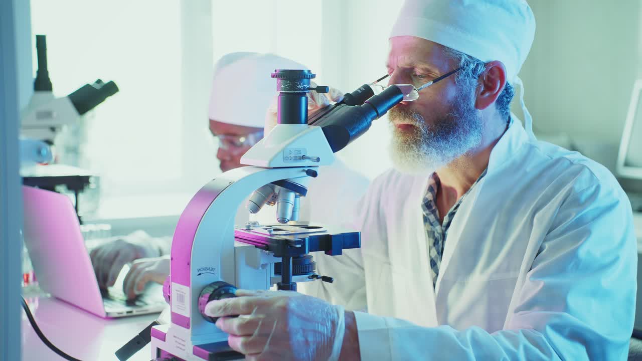 Scientists Working with Microscope and Laptop in a Modern Laboratory
