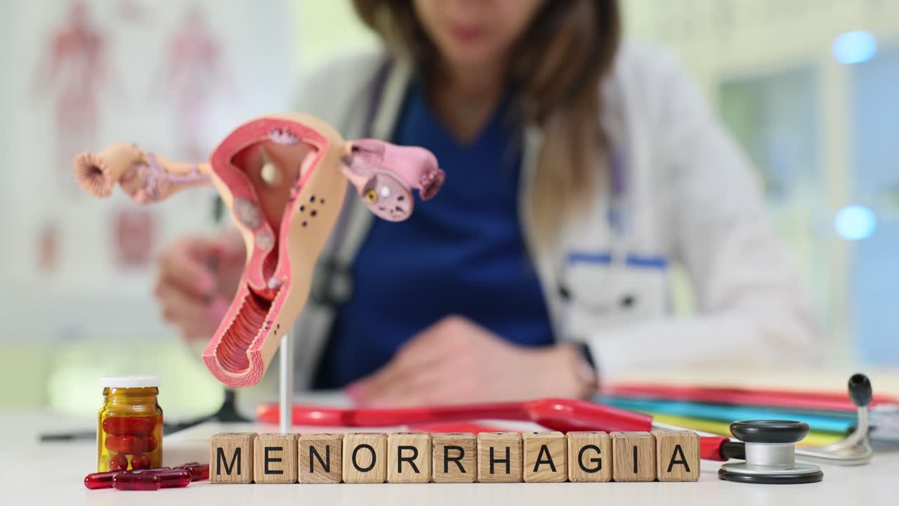 Menorrhagia Word with Uterus Model and Doctor in Medical Office