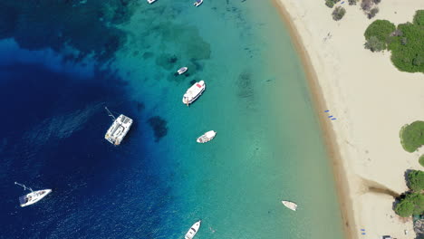 Aéreo:-Veleros-Y-Catamaranes-En-La-Playa-De-La-Isla-Tsougria-Cerca-De-Skiathos,-Esporadas,-Grecia