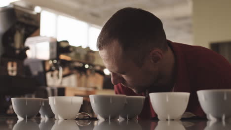 handsome barista sniffing different types of coffee