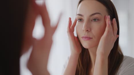 mujer comprobando su cara en un espejo