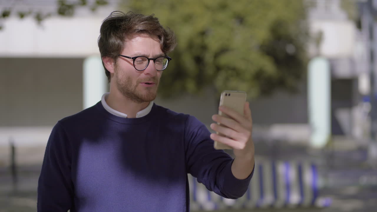 hombre feliz hablando por teléfono inteligente en la calle
