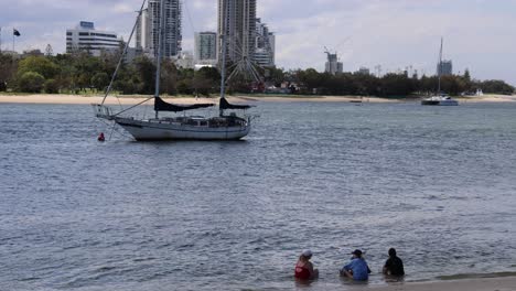 sailboat moving on river with cityscape backdrop