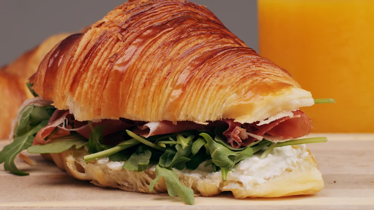 Croissant with jamon ham, Salmon, in Modern Cafe, Top View of Healthy Breakfast in Cafe. English breakfast: fried egg, bacon toast on sandwich.