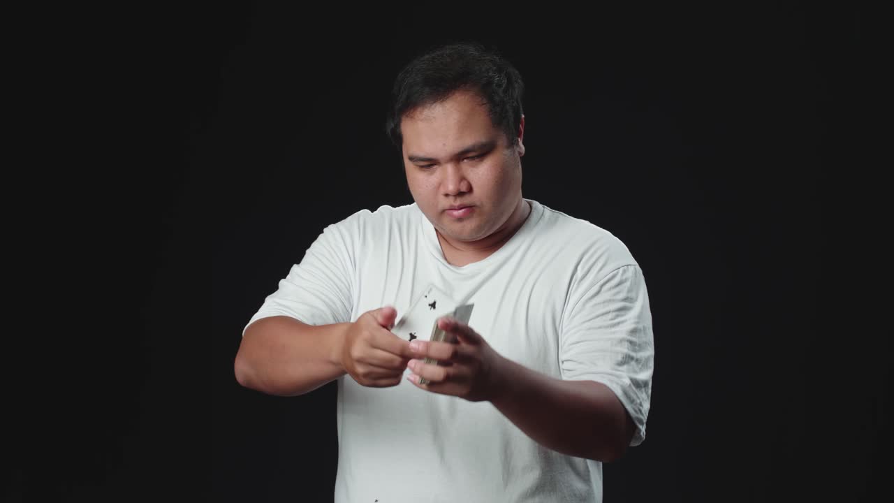 Asian Man Showing His Trick With Usual Cards, Cardistry On Black Background