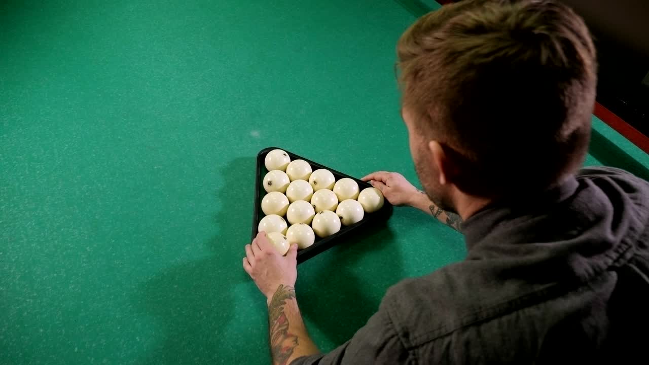 un hombre que se prepara para comenzar un juego de billar.