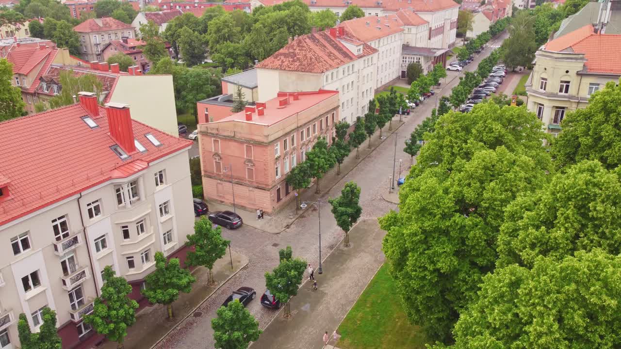 árboles verdes y edificios de apartamentos de la ciudad de klaipeda, vista aérea ascendente