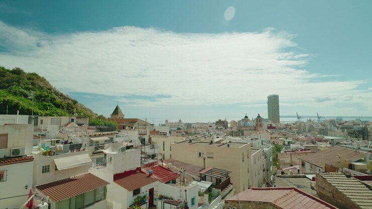Veduta sopraelevata del paesaggio urbano di Alicante sotto un cielo azzurro nuvoloso