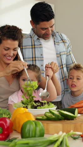 padres haciendo una ensalada con sus hijos