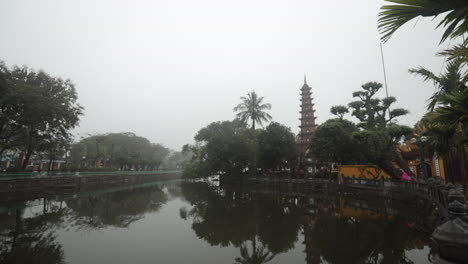 Tran Quoc Pagoda by a tranquil lake with a foggy morning backdrop in Sa Pa, Vietnam