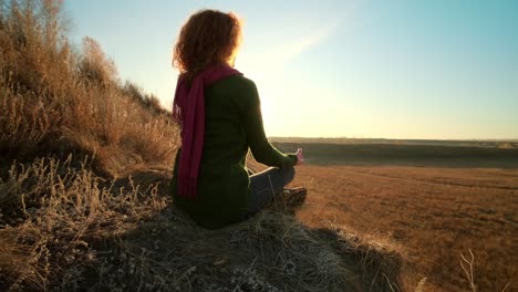 mujer meditando al atardecer