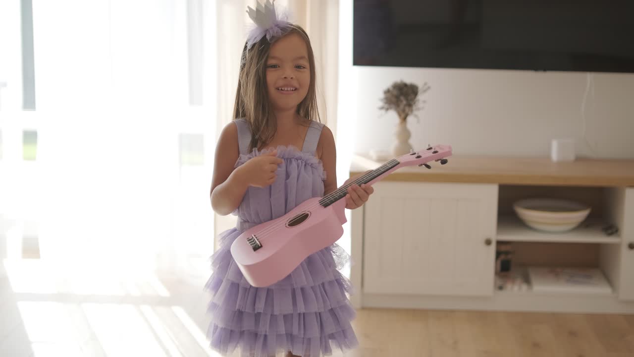 una hermosa niña está tocando el ukulele en la sala de estar para su madre.