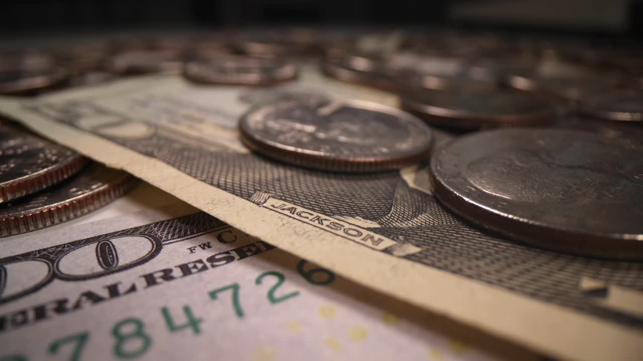 Koyu arka plan üzerinde dolarlar ve madeni paralar