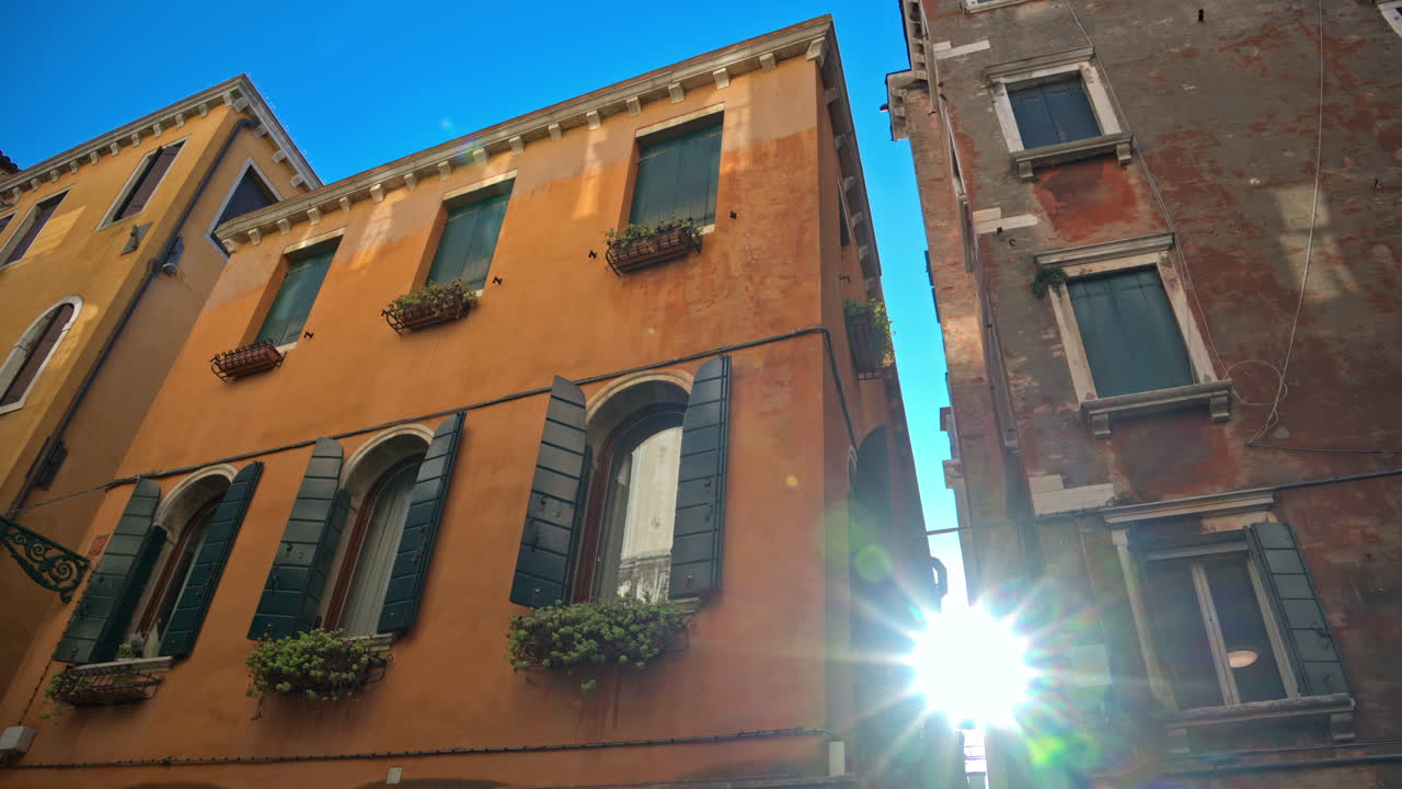 The sun peaking through the buildings of Venice City, Italy