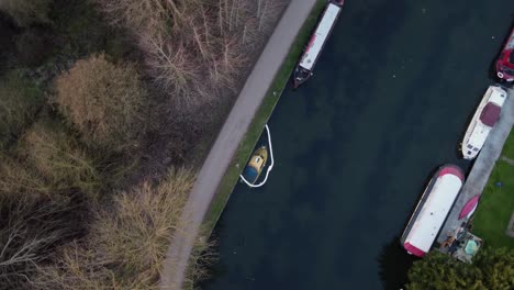 Antena-De-Arriba-Hacia-Abajo-De-Un-Pequeño-Puerto-Fluvial-Con-Botes-De-Estacionamiento-Y-Una-Lancha-Motora-Hundida-Con-Fuga