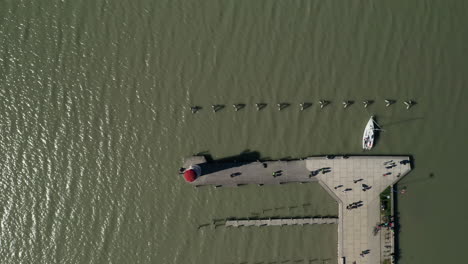 vista aérea de pájaros dolly shot de un antiguo faro con un muelle