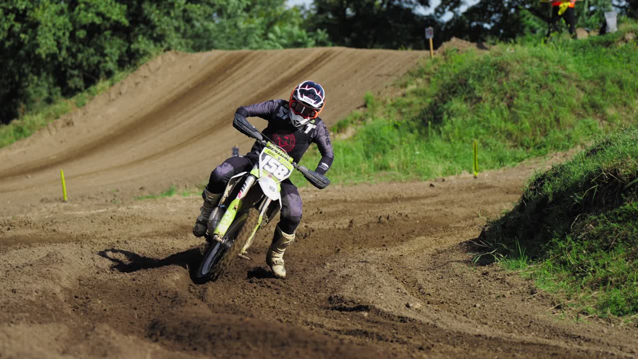 Piloto de motocross inclinando-se em uma curva, colocando o peso na frente