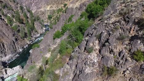 Vista-Aérea-Descendente-De-Las-Empinadas-Paredes-Del-Cañón-Con-Un-Río-De-Aguas-Bravas-Que-Fluye-Debajo