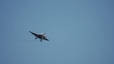 military jet with extended landing gear executes dynamic aerial maneuvers, filmed in slow motion