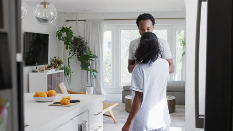 loving couple wearing pyjamas having romantic dance in kitchen at home together