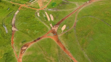 Drohnenaufnahme-Von-Dirtbikes-Durch-Den-Schlamm,-Drohnenaufnahmen-Von-Oben-Nach-Unten