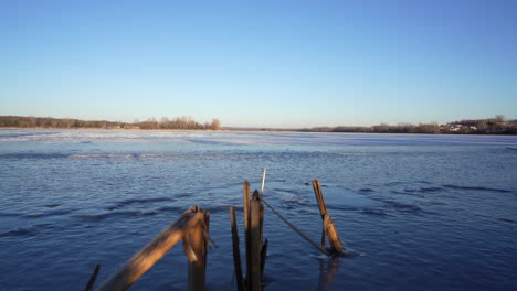 pan shot of a frozen lake in winter by sunset