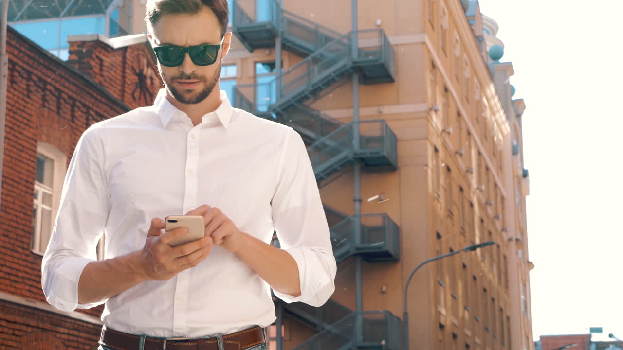 Uomo d'affari che usa lo smartphone in città