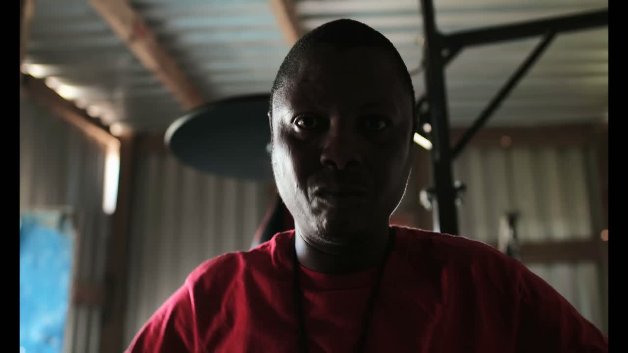 아프리카계 미국인 남성이 피트니스 스튜디오 4k에서 손 주먹을 형성하고 서 있습니다.