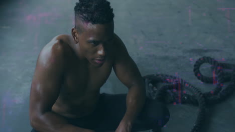 crouching on floor, shirtless man with short hair appearing focused and determined
