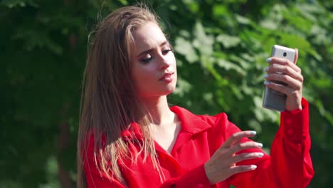 beautiful girl taking selfie. portrait of beautiful young woman taking selfie in the park with smartphone