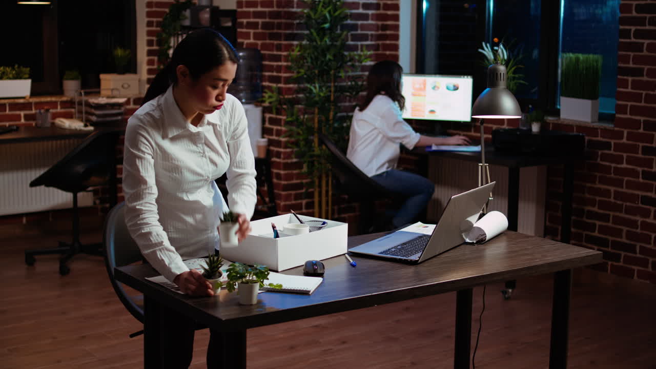 empregado triste embalando coisas da secretária depois de desistir do emprego, dizendo adeus ao colega