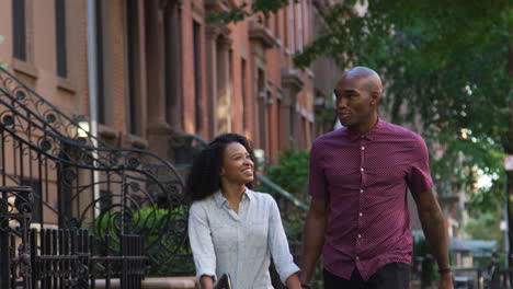 young couple walking along urban street in new york city