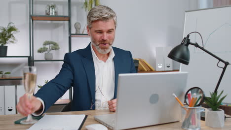 Business-man-working-on-laptop-celebrate-successful-contract-agreement-with-colleague-at-office