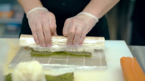 Close-up-cooking-Japanese-rolls-using-mat-with-cucumber-and-ginger