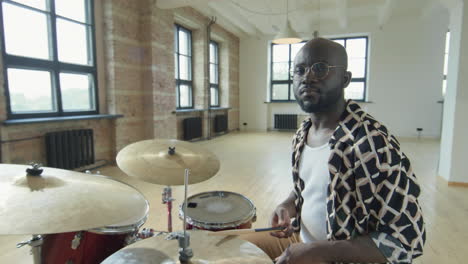 portrait of black drummer at drumset in studio