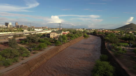 Flowing-Brown-Waters-Of-Santa-Cruz-River-In-Tucson,-Arizona-On-A-Sunny-Day-After-The-Rain