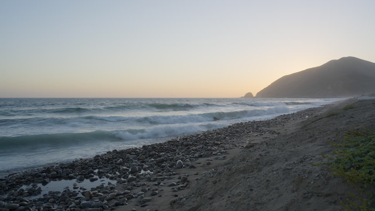 vista a nivel de la playa de las olas rompiendo en las orillas de la playa de mondo a la hora dorada cuando sube la marea ubicada en el sur de california, estados unidos