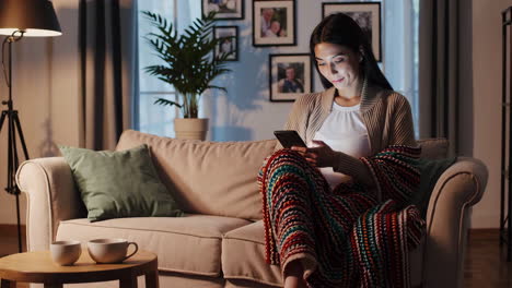 woman relaxing on couch using smartphone