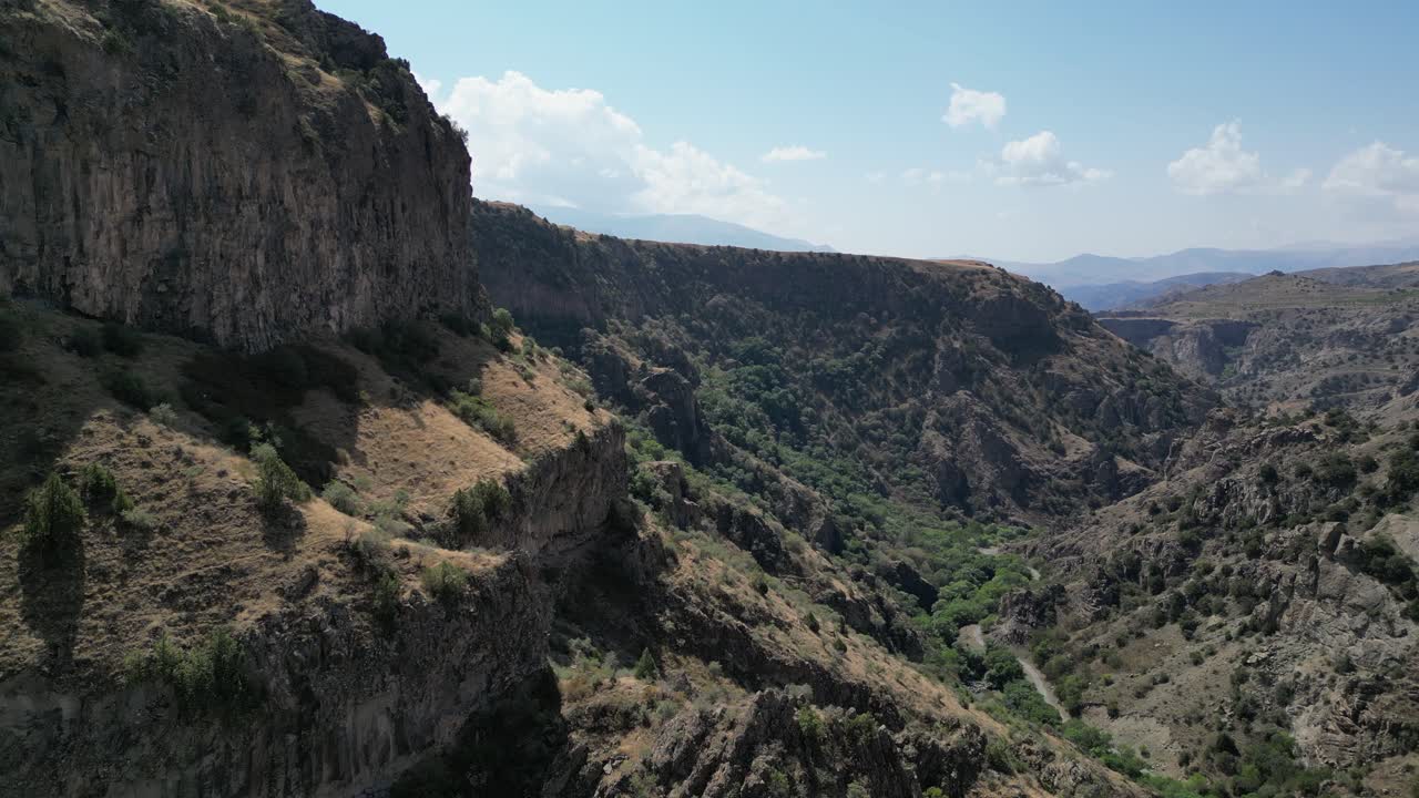 Volo aereo lungo una ripida parete rocciosa in una valle canyon aspra, Armenia