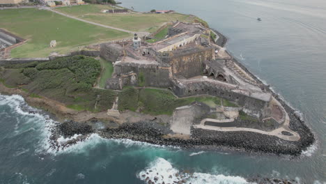 old and historic el morro citadel with ocean waves crashing on the rocky shoreline in san juan, puerto rico