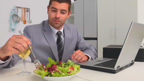 businessman working on his laptop while he is eating