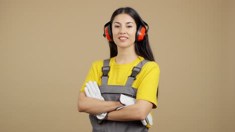 woman in workwear with ear defenders and gloves